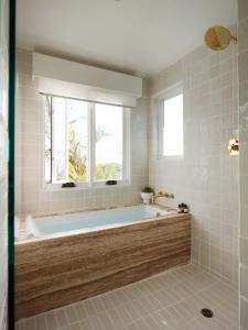 a bath tub in a bathroom with a window at Hotel Joaquin - Adults Only in Laguna Beach