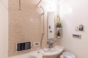 a bathroom with a shower with a tv on the wall at Villa de Class in Osaka +39 photos