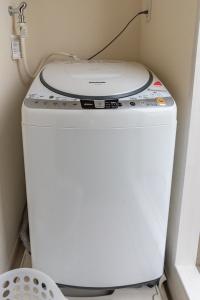 a washing machine sitting on top of a toilet at Villa de Class in Osaka