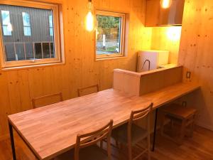 a kitchen with a wooden table and chairs at Sumika in Furano