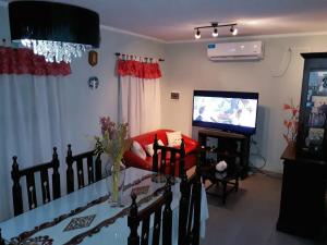 sala de estar con silla roja y TV en Casa de Vacaciones ADELITA en Establecimiento Las Costas