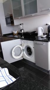 a kitchen with a washing machine under a counter at Lou-Jos in Funchal