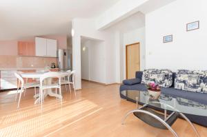 ein Wohnzimmer mit einem blauen Sofa und einem Tisch in der Unterkunft Apartments Sweet garden in Vodice