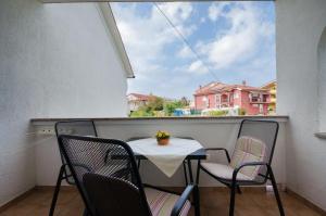 a small table and chairs on a balcony at Apartments Helena in Lopar