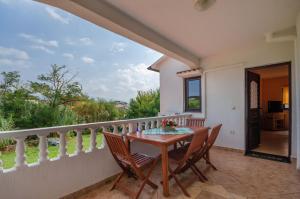 a dining room with a table and chairs on a balcony at Apartments Helena in Lopar