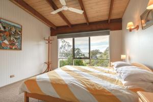 a bedroom with a large bed and a window at Millimgimbi in Metung