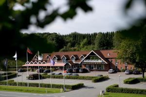 a hotel with cars parked in a parking lot at Nilles Kro in Sabro
