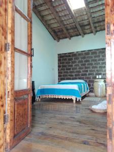 a bedroom with a bed and a brick wall at Casa del siglo XVII in Jocotitlán