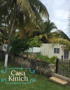 a sign in front of a house with palm trees at CASA KINICH SISAL in Sisal