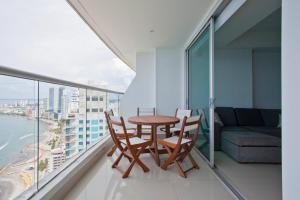 balcón con mesa, sillas y sofá en Palmetto Eliptic 4003, en Cartagena de Indias