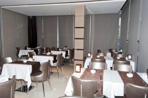 a dining room with white tables and chairs and tablesktop at Sultan Hotel in Mersin