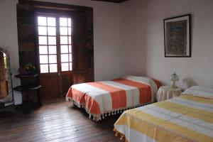 1 Schlafzimmer mit 2 Betten und einem Fenster in der Unterkunft Casa del siglo XVII in Jocotitlán