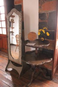 einen Spiegel mit einem Tisch und einem Stuhl in einem Zimmer in der Unterkunft Casa del siglo XVII in Jocotitlán