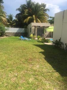 a yard with chairs and a building and a pool at CASA KINICH SISAL in Sisal
