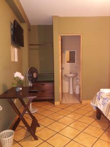 a room with a bathroom with a toilet and a table at Hostal Tambo Colorado in Pisco