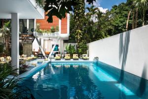 a swimming pool with chairs and a building at Viroth's Villa in Siem Reap