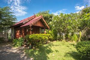 a small wooden house with a red roof at Greenhouse resort in Buriram