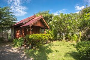 una piccola casa in legno con tetto rosso di Greenhouse resort a Buriram