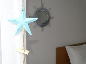 a blue starfish hanging from a window with a mirror at Balada dos Mares Vila in Vila do Conde