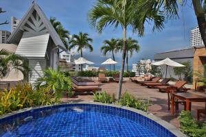 a swimming pool with chairs and umbrellas at a resort at Sunshine Vista Hotel in Pattaya Central