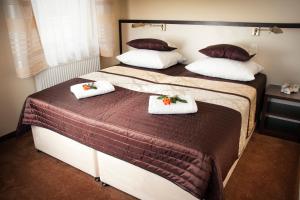 two beds in a room with towels on them at Villa Gardena in Gdynia