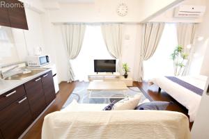 宜野湾市にあるLa Fonte UK2のベッド2台とシンクが備わる小さな客室です。