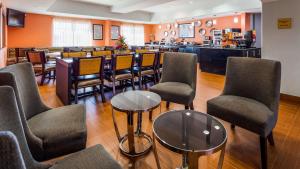 ein Restaurant mit Stühlen und Tischen sowie eine Bar in der Unterkunft Best Western Plus Barsana Hotel & Suites in Oklahoma City