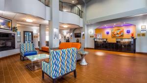 a lobby with chairs and a table in a building at Best Western Plus Barsana Hotel & Suites in Oklahoma City