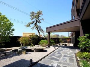 a patio with benches in front of a building at Yunokawa Onsen Emi Hakodateya in Hakodate