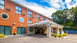 a large red brick building with a garage at Best Western Cape Cod Hotel in Hyannis