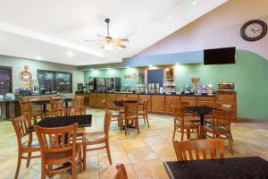 un restaurante con mesas, sillas y una barra en AmericInn by Wyndham New London, en New London