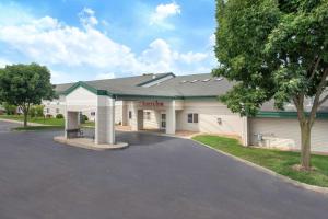 a building with a parking lot in front of it at AmericInn by Wyndham Boscobel in Boscobel