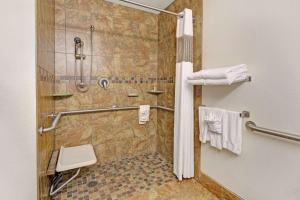 uma casa de banho com chuveiro, WC e toalhas em Microtel Inn & Suites Cheyenne em Cheyenne