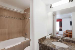 a bathroom with a sink and a mirror at Super 8 by Wyndham Santa Clarita/Valencia in Santa Clarita +29 photos