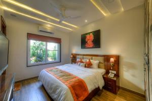 a bedroom with a large bed and a window at Joystreet - Beachy Blossom in Siolim