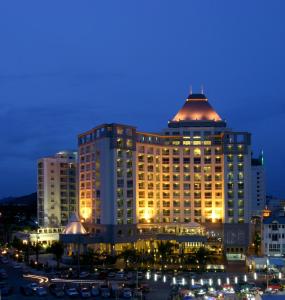 um grande edifício com luzes acesas numa cidade à noite em Cape Racha Hotel em Si Racha