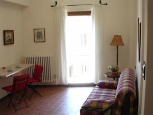 sala de estar con sofá, mesa y ventana en Casa Vacanze Del Pescatore, en Passignano sul Trasimeno