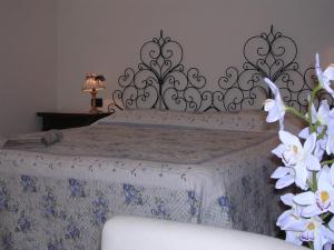 a bedroom with a bed with a bedspread and flowers at Casa Vacanze Del Pescatore in Passignano sul Trasimeno +12 photos