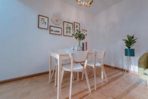 a white dining room with a white table and chairs at Xi’an Beilin·Xiaozhai· Locals Apartment 00178070 in Xi'an