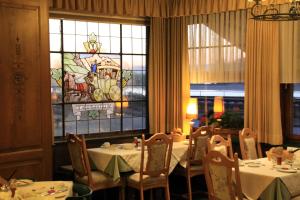 a dining room with tables and a stained glass window at Pension Post Rüdesheim in Rüdesheim am Rhein