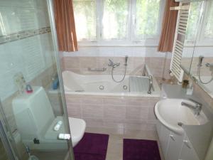 un bagno con vasca, WC e lavandino di B&B Pappelweg - 2 a Muttenz