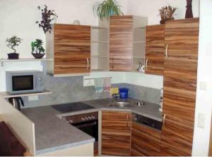 una cucina con armadi in legno e lavandino di Appartement Annemarie a Brixen im Thale