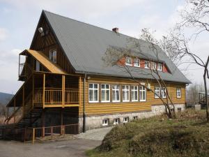 a large wooden house with a black roof at Szkolne Schronisko Młodzieżowe Złoty Widok in Piechowice