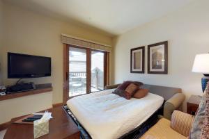a living room with a bed and a large window at The Cache in West Village in Copper Mountain