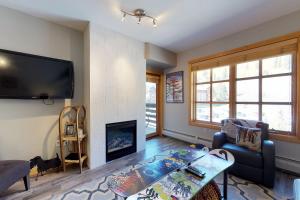 uma sala de estar com lareira e uma televisão de ecrã plano em Passage Point 422 em Copper Mountain