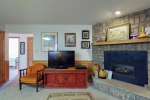 ein Wohnzimmer mit einem TV und einem Kamin in der Unterkunft Snowfire 208B in Angel Fire