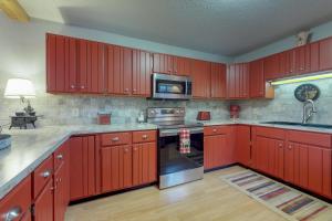 een keuken met rode kasten en een fornuis met oven bij Eagle View G2 in Estes Park