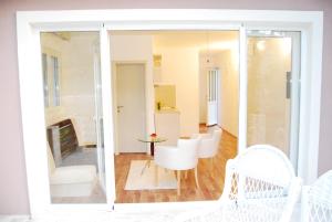 a living room with a table and white chairs at Hotel Art Media in Herceg-Novi