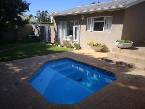 a blue swimming pool in the backyard of a house at On Cloud 9 in Hermanus