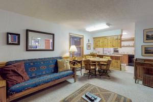 ein Wohnzimmer mit einem blauen Sofa und einer Küche in der Unterkunft Snowfire 208B in Angel Fire